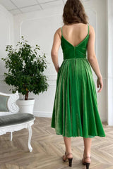 Holiday party dress in green velvet with spaghetti straps and an A-line cut