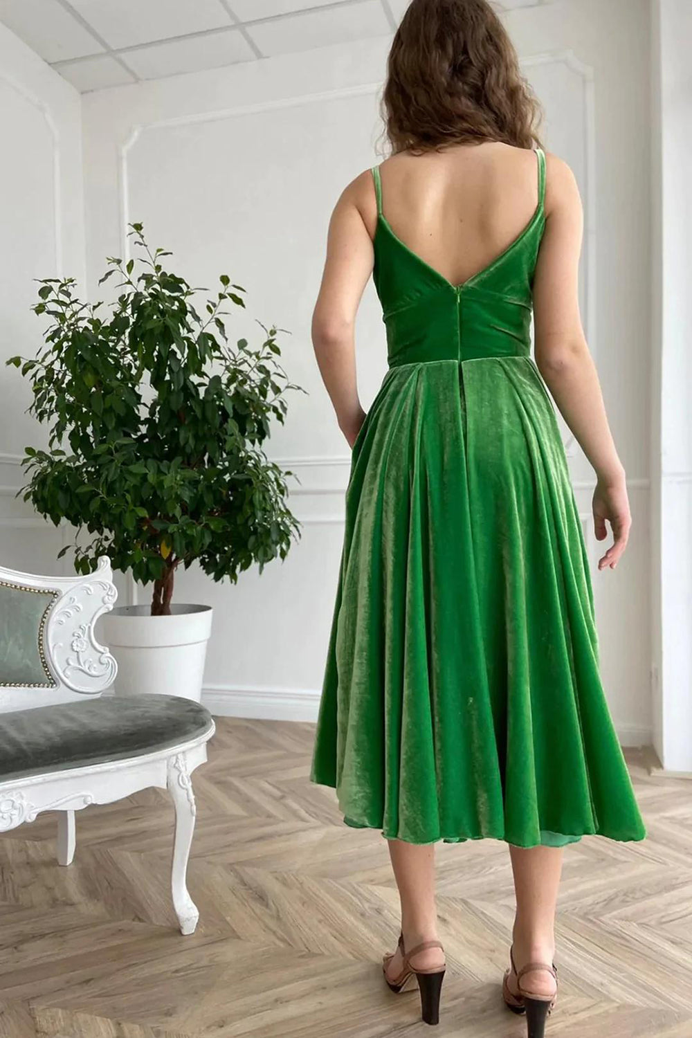 Holiday party dress in green velvet with spaghetti straps and an A-line cut