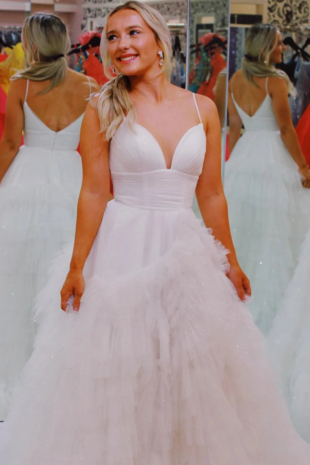Pink long prom dress with spaghetti straps and ruffles in an A-line silhouette